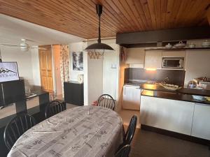 eine Küche mit Tisch und Stühlen in einem Zimmer in der Unterkunft Appartement spacieux en montagne avec loggia, au cœur de la station, proche piste et lac - FR-1-814-62 in Besse-et-Saint-Anastaise
