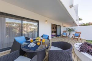 un patio con mesa y sillas en una terraza en NOA Apartment Quinta do Lago, en Quinta do Lago