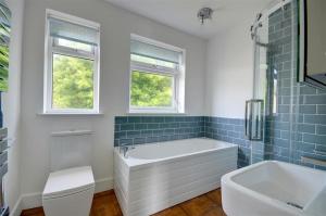 a bathroom with a tub and a toilet and a sink at 5 Bed in Woolacombe oc-alba12 in Woolacombe +28 photos