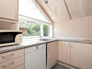 a kitchen with a sink and a microwave at 8 person holiday home in Idestrup-By Traum in Marielyst