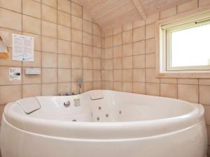 a white tub in a bathroom with a window at 8 person holiday home in Idestrup-By Traum in Marielyst