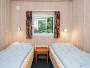 two beds in a room with a window at 7 person holiday home in Henne-By Traum in Henne Strand