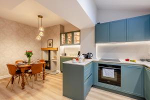 伊尔克利Ilkley Moor View Cottage的厨房配有蓝色橱柜和桌椅