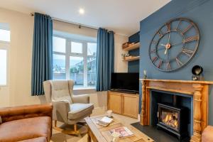 伊尔克利Ilkley Moor View Cottage的一间带时钟和壁炉的客厅