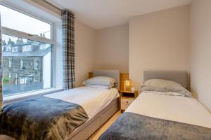 伊尔克利Ilkley Moor View Cottage的有窗户的房间里有两张床