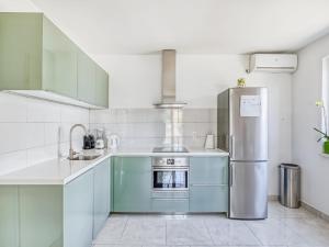 a kitchen with blue cabinets and a refrigerator at Villa in Orebić near Sea Beach in Orebić