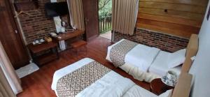 a living room with a white couch and a brick wall at Giri Tengah Resort Borobudur in Ngargoremo