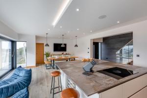 cocina abierta y sala de estar con sofá azul en Combesgate View, en Mortehoe
