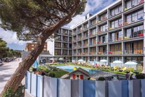 un hotel con piscina frente a un edificio en GHT Sa Riera, en Tossa de Mar