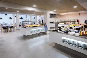 Un restaurante con un buffet de comida en exhibición. en GHT Sa Riera, en Tossa de Mar
