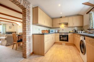 a kitchen with wooden cabinets and a table in a room at Mallard Cottage - Padstow in St Merryn +20 photos