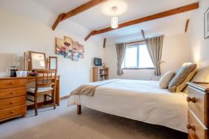 a bedroom with a bed and a desk and a chair at Mallard Cottage - Padstow in St Merryn
