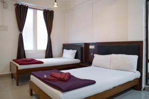 ein Hotelzimmer mit zwei Betten und einem Fenster in der Unterkunft Ocean View in Port Blair