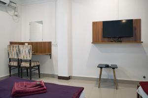 a room with a tv and a chair and a table at Ocean View in Port Blair