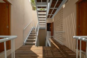 a staircase in a building with wooden floors and white rails at Cholula Condesa Hotel by Lumina in Mexico City