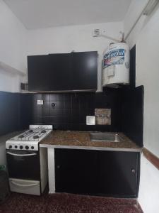 a kitchen with a stove and a sink at Alquiler en las Toninas a 2 cuadras del mar in Las Toninas