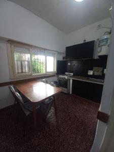 a kitchen with a wooden table in the middle of it at Alquiler en las Toninas a 2 cuadras del mar in Las Toninas