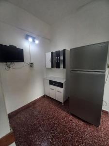 a small kitchen with a refrigerator and a tv at Alquiler en las Toninas a 2 cuadras del mar in Las Toninas +2 photos
