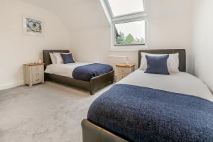 卡比斯贝Chapelporth - St Ives的一间卧室设有两张床、一张沙发和一个窗口