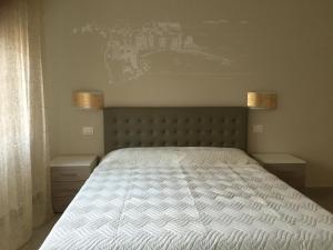 1 dormitorio con 1 cama blanca y 2 luces en la pared en Affittacamere La Perla, en La Spezia