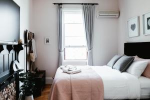 a bedroom with a large white bed with a window at Historic Benambra Boutique Hotel Queenscliff c1883 in Queenscliff