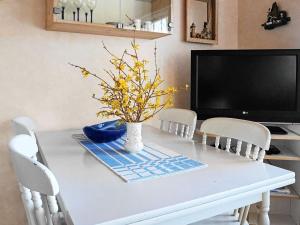 a dining room table with a vase of flowers on it at 4 person holiday home in Ellös in Ellos +21 photos