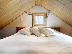 a bed in a room with a roof with a window at 4 person holiday home in Ellös in Ellos