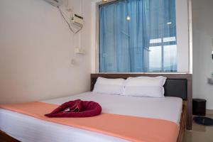 ein Bett mit einer roten Decke darauf und einem Fenster in der Unterkunft Ocean View in Port Blair