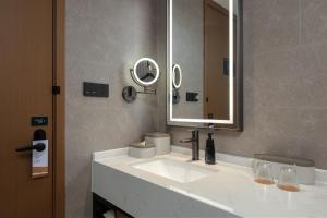 Atour Hotel Changsha Yuelu Mountain Orange Isle في تشانغشا: حمام مع حوض أبيض ومرآة