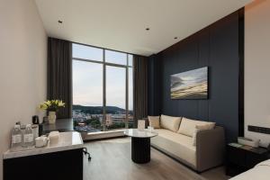 Atour Hotel Changsha Yuelu Mountain Orange Isle في تشانغشا: غرفة معيشة مع أريكة ونافذة كبيرة