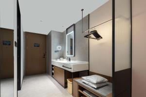 Atour Hotel Changsha Yuelu Mountain Orange Isle في تشانغشا: حمام مع حوض ومرآة