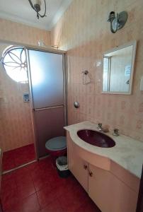 a bathroom with a sink and a toilet at Moradias Guabi in Curitiba