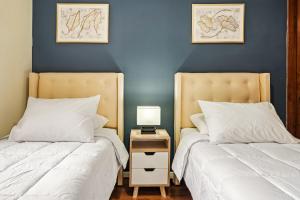 two beds sitting next to each other in a bedroom at Estreno - Bellas Artes Turístico in Santiago