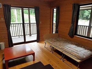 a room with a bed and a table and windows at Shiobara Onsen Activity Club - Vacation STAY 86348v in Shiobara-machi