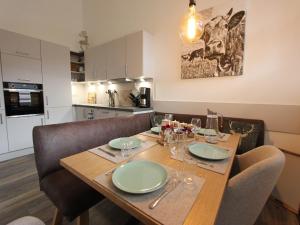 a dining room table with chairs and a table and a cow on the wall at Apartment in Kirchdorf near Ski Slopes in Kirchdorf in Tirol