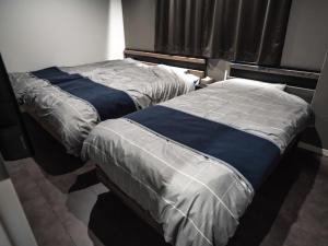 two beds sitting next to each other in a room at Kotonoyado Chizu - Vacation STAY 83866v in Kotohira