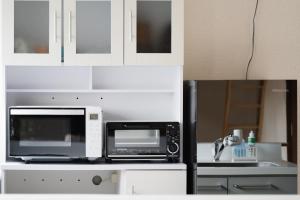 a white kitchen with a microwave and a sink at Private stay Peaceful - Vacation STAY 18247 in Minamiawaji