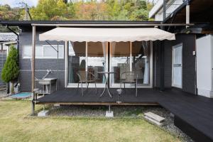 a porch with a table and chairs and an umbrella at Private stay Peaceful - Vacation STAY 18247 in Minamiawaji