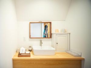 a bathroom with a white sink and a mirror at Gramercy Village Lake Yamanaka Glamping & Sauna - Vacation STAY 92836v in Yamanakako +18 photos