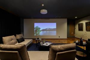 ein Wohnzimmer mit einem Sofa und einer Leinwand in der Unterkunft Gracia Kamiiida - Vacation STAY 18274 in Nagoya