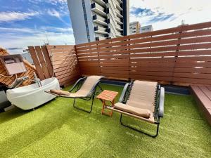 einen Balkon mit einer Badewanne, 2 Stühlen und einer Badewanne auf einem Gebäude in der Unterkunft Gracia Kamiiida - Vacation STAY 18274 in Nagoya