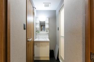 ein Badezimmer mit einem weißen Waschbecken und einem Spiegel in der Unterkunft Gracia Kamiiida - Vacation STAY 18274 in Nagoya + 83 Fotos