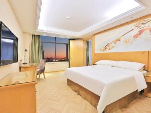a bedroom with a large white bed and a window at Vienna Hotel Hunchun East Market Government Affairs Center in Hunchun +30 photos