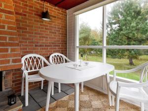 a white table and chairs in a room with a window at 5 person holiday home in GLOMMEN-By Traum in Glommen
