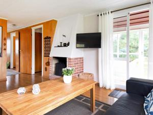 a living room with a table and a fireplace at 5 person holiday home in GLOMMEN-By Traum in Glommen