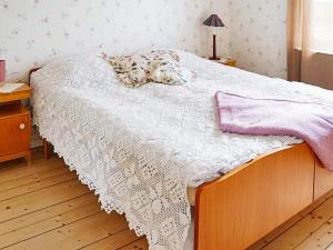 a bedroom with a bed with a dog laying on it at 6 person holiday home in Odensvi in Gamleby