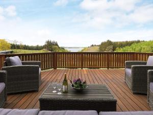 a deck with a table with a bottle of wine at 4 star holiday home in Skals in Skals
