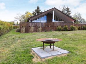 a table in the grass in front of a house at 8 person holiday home in Skals in Skals