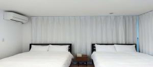 two beds sitting next to each other in a bedroom at Tabinoteitaku Y-beach - Vacation STAY 91093v in Tsuruoka +2 photos