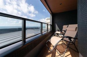 two chairs on a balcony with a view of the ocean at Tabinoteitaku Y-beach - Vacation STAY 91093v in Tsuruoka